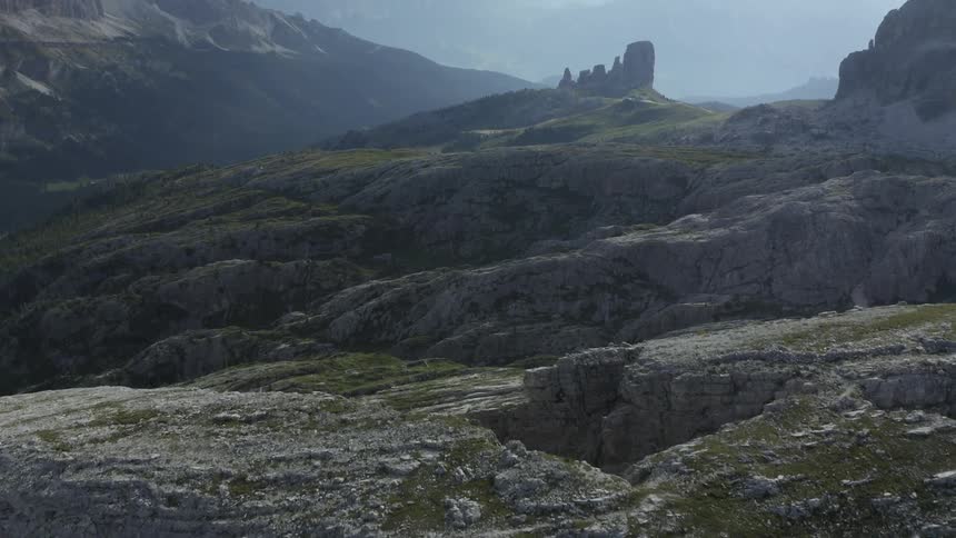 Mist covers mountainous terrain of stone and moss
