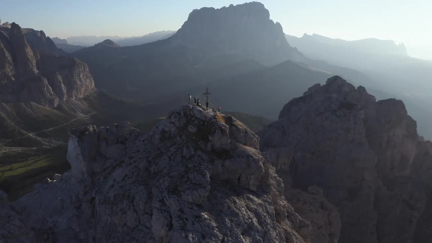 People stand at a memorial on top of a mountain