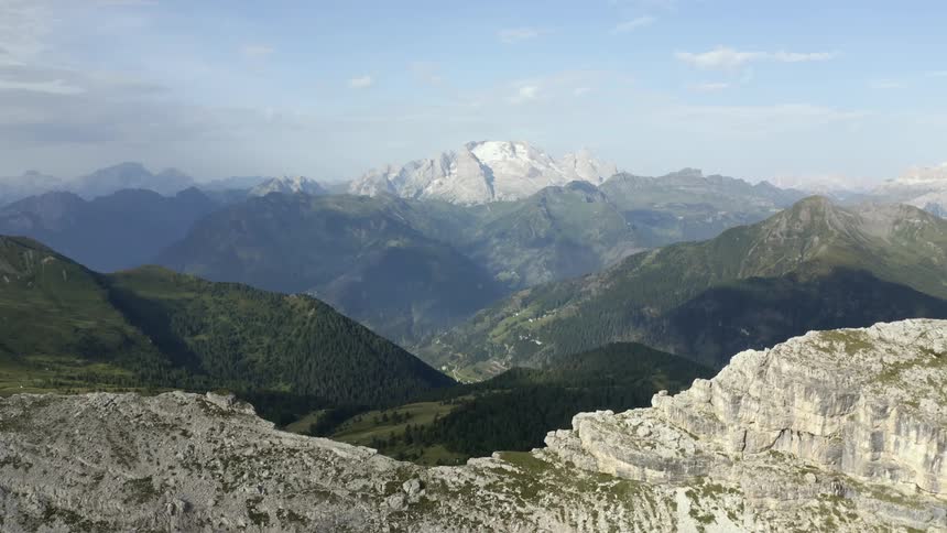 Green slopes of the mountains close to the barren cliffs of a mountain peak