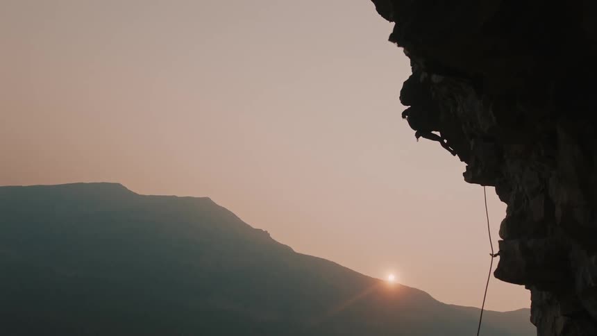 A man falls and hangs from the rope while mountain climbing