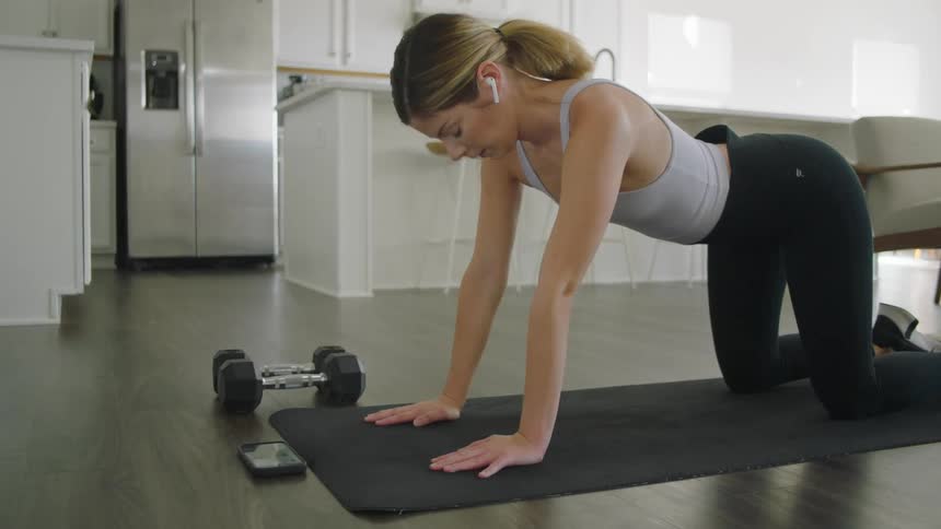 A woman is doing yoga on a mat