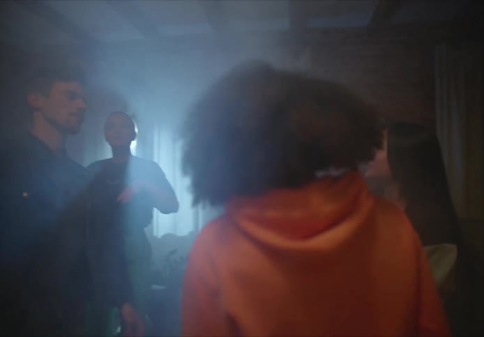 Group of teenagers dancing in a dark smoky room