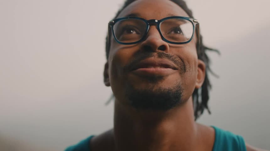 Man with eyes closed opens his eyes and smiles before starring