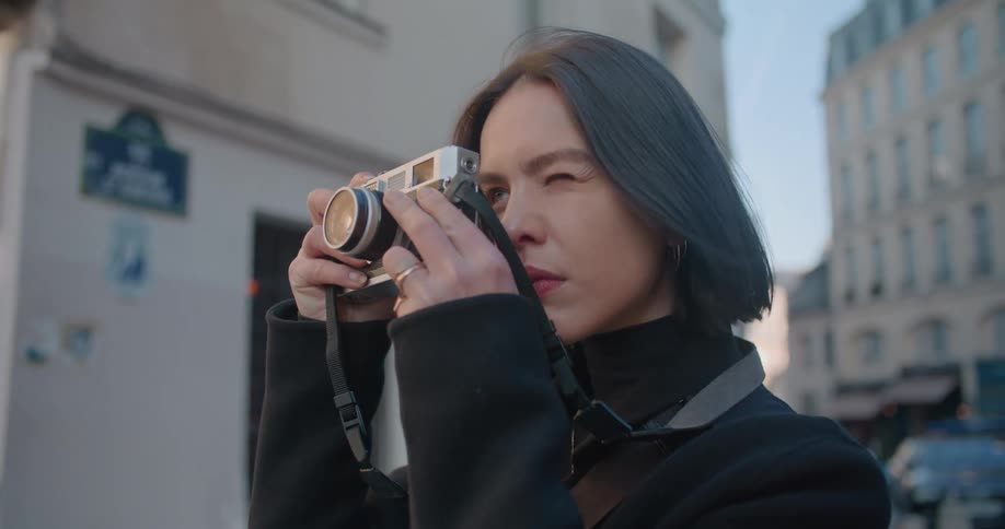 A woman is taking a photograph outside