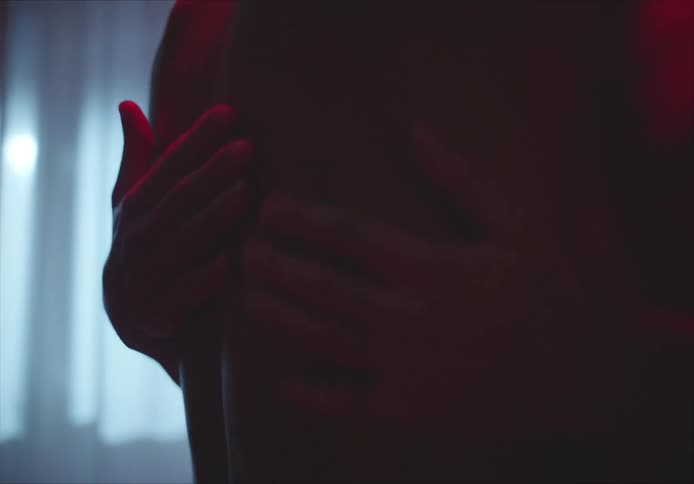 A man without a shirt on dances closely and rubs another mans bare back