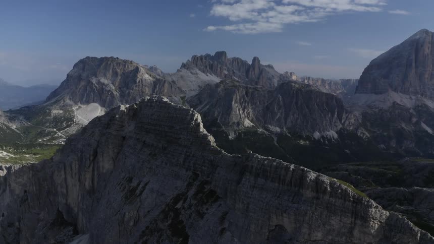 Aerial view of a solitary mountain in a valley close a mountain range in the morning