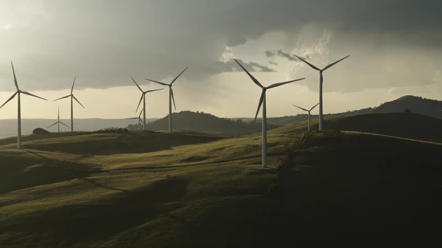 Aerial view of wind turbines on wind farm at sunset