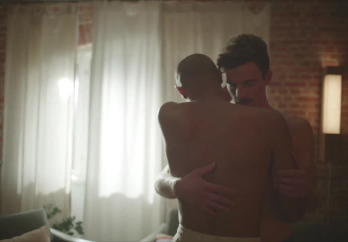 Two men slow dance topless in their living room