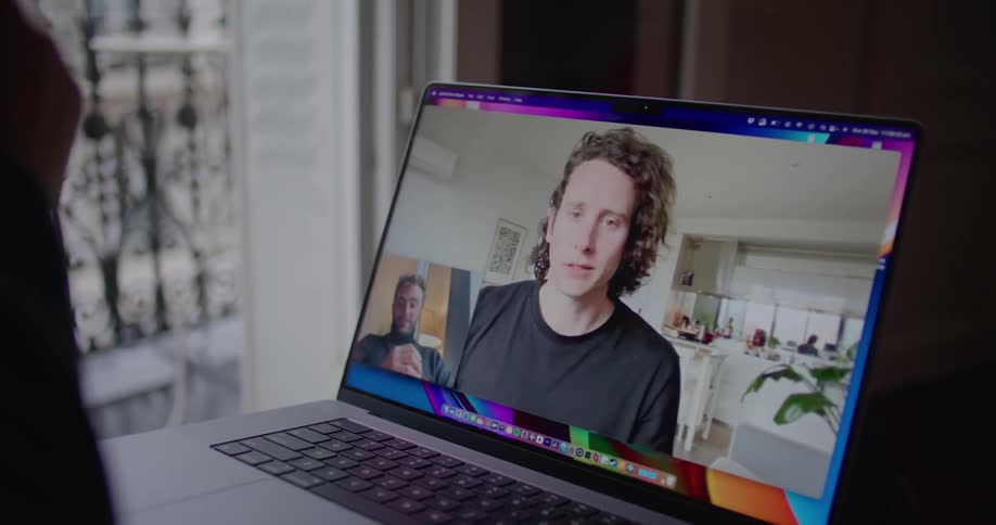 Two friends talking on a video call through a laptop