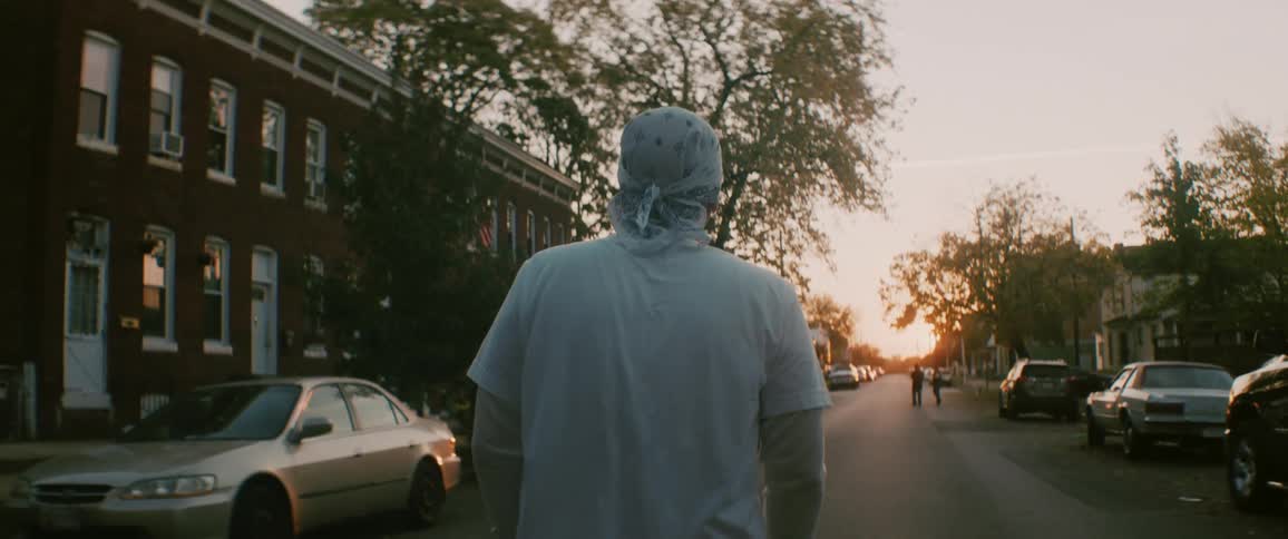 A man walks down a street in a neighborhood