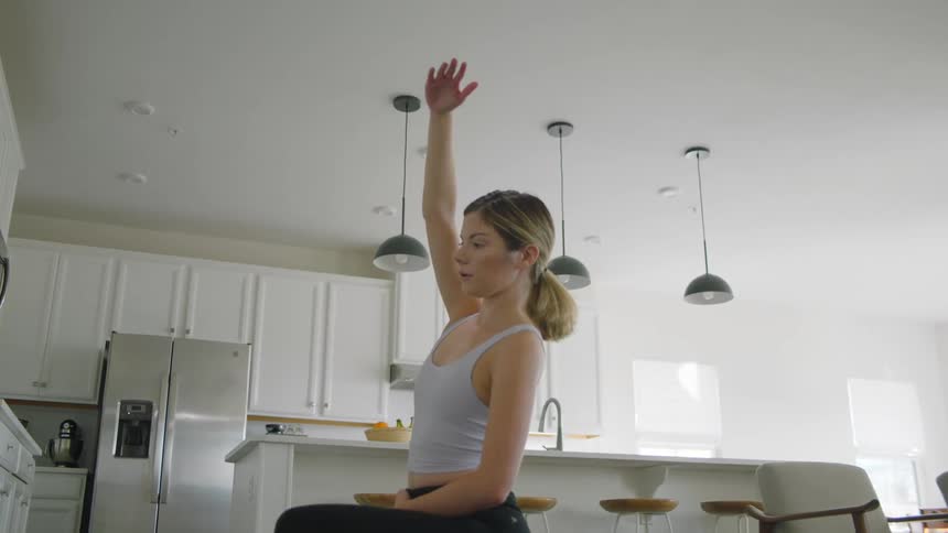 A woman holding a yoga pose in the kitchen
