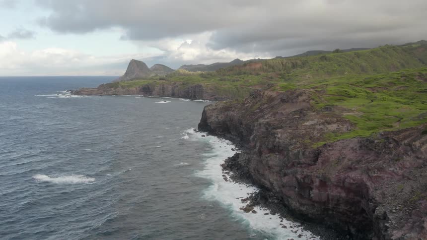Aerial view of shoreline with cliffs on cloudy day