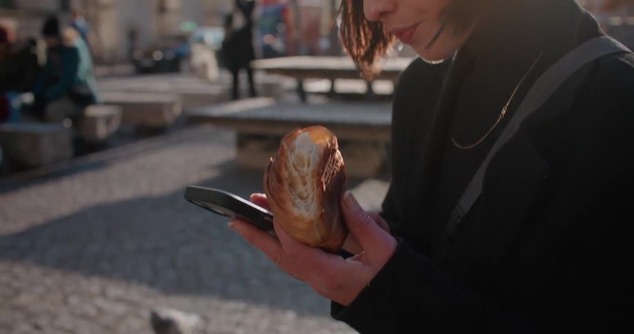 A woman is eating outside in the city