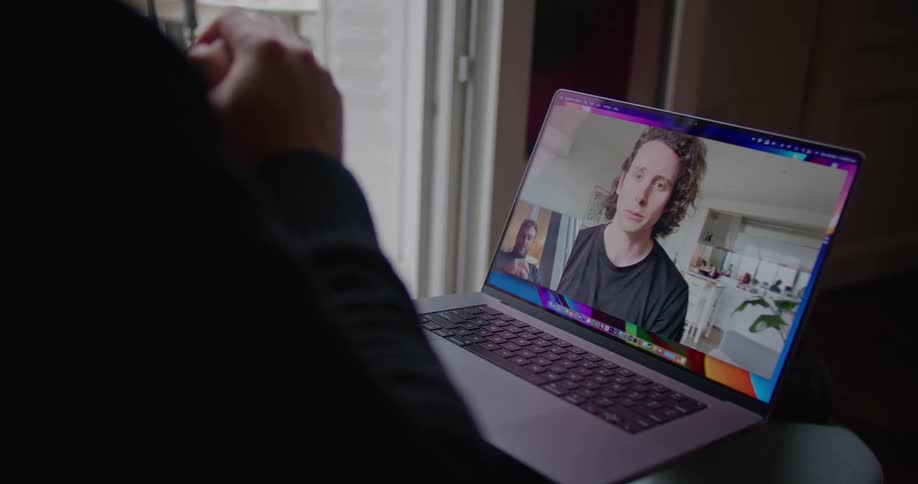 Two friends talking on a video call through a laptop