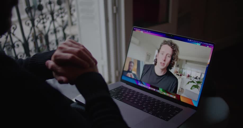 Two friends having a conversation on a video call over a laptop