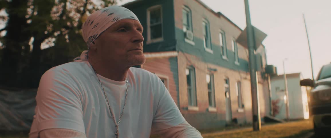 A man sits by the road in town