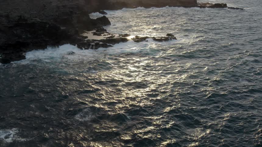 Ocean waves splash and foam against a rocky shore