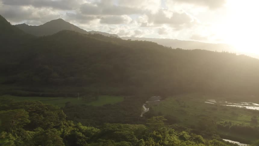 Aerial view of mountain forests with valley at sunset