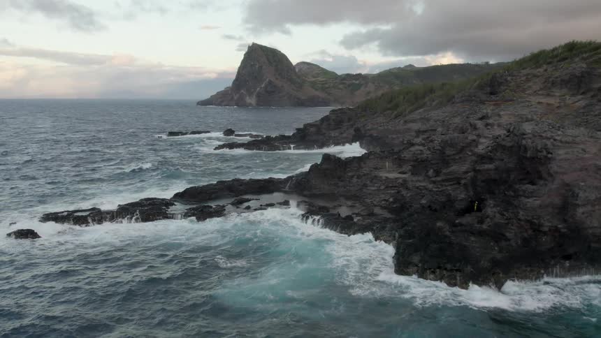 An aerial view of the coast with waves crashing