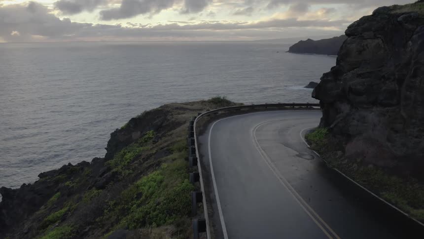 Curving highway hugs slope leading down to ocean