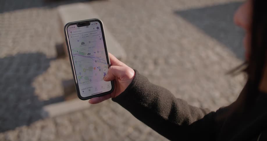 A woman scrolling through directions on cell phone