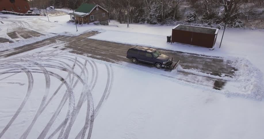 A truck plowing a parking lot