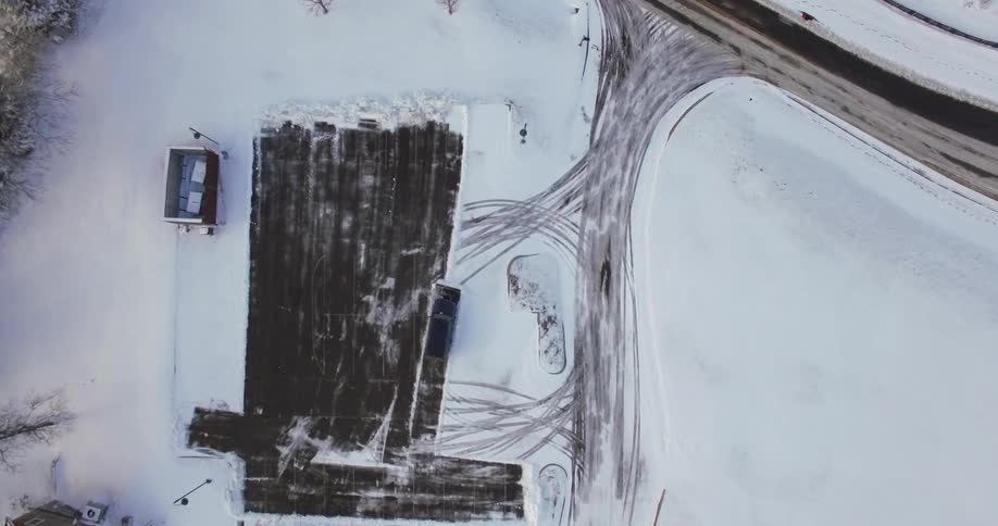A bird's-eye-view of an suv plowing a parking lot
