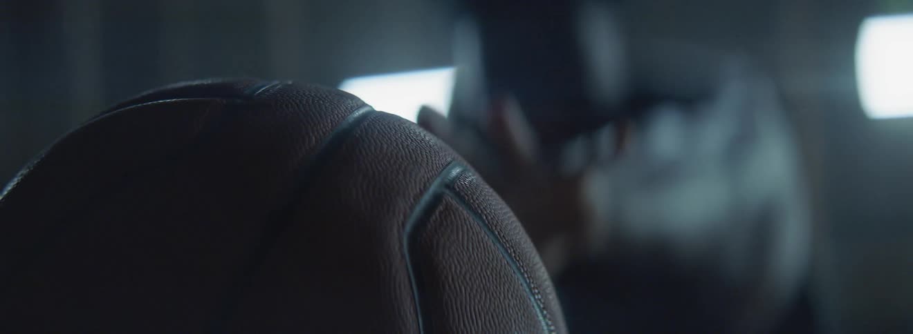 A man is blurry in the distance reaching for a basketball