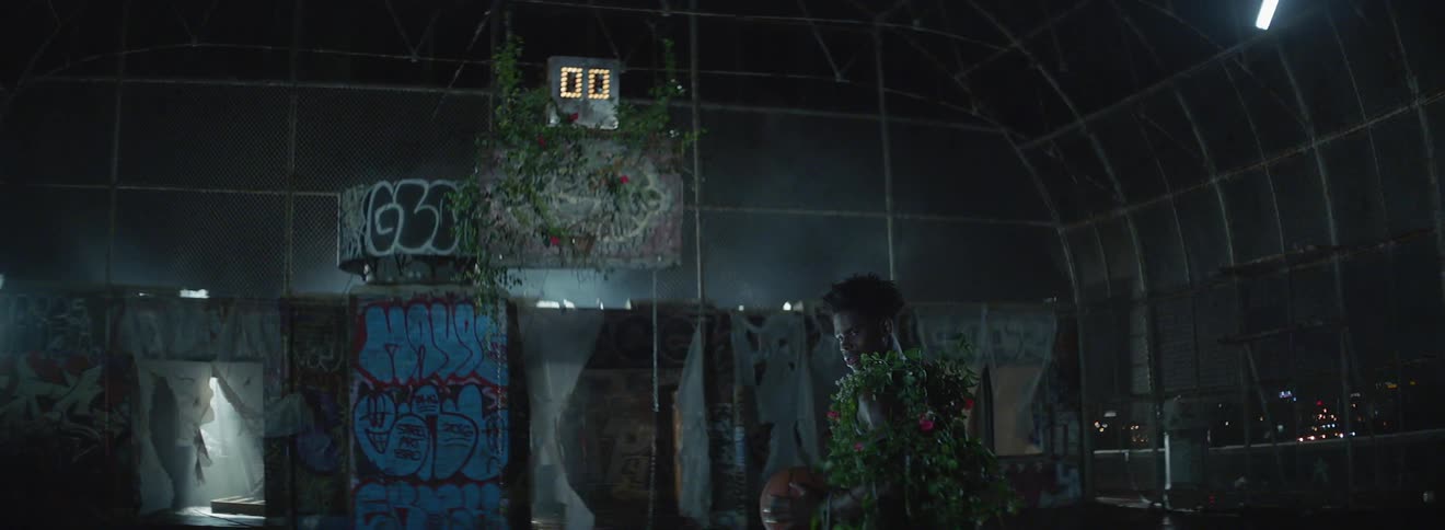 A man covered in vines is holding a basketball