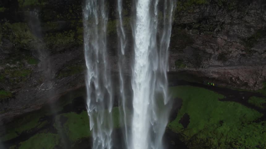 Aerial view of cars traveling on roads near a waterfall