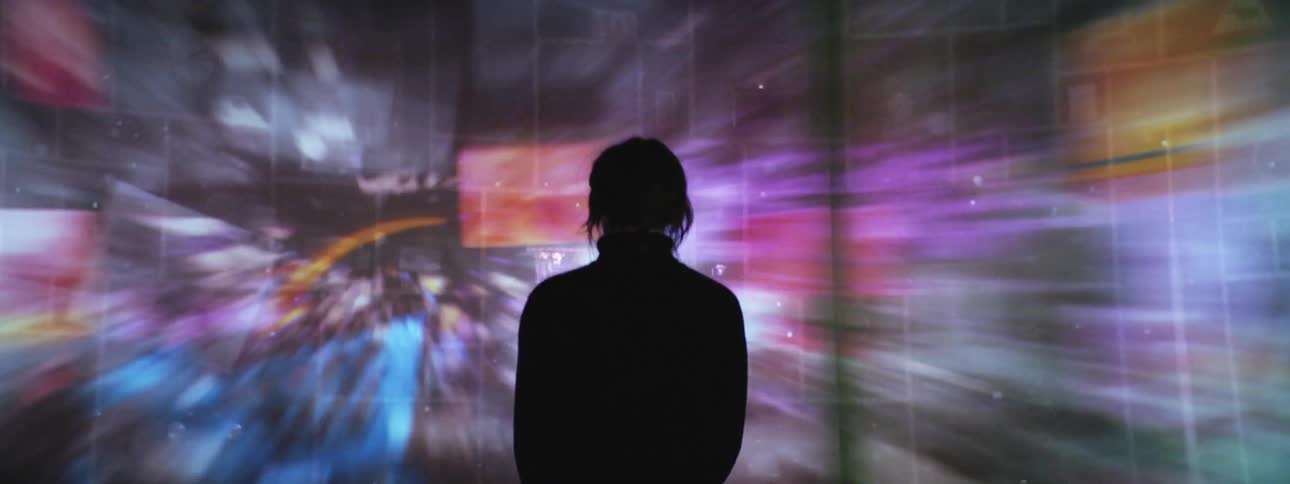 A person standing in a room with screens