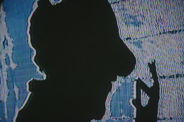 Silhouette of mans head on a screen and his hand moving in front of his face surrounded by white and blue lines