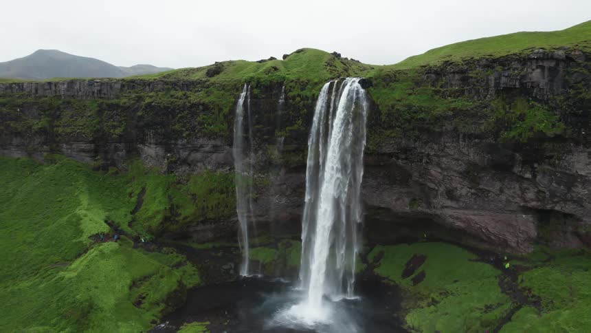Birds fly around waterfalls flowing of plateau anddown cliff to river