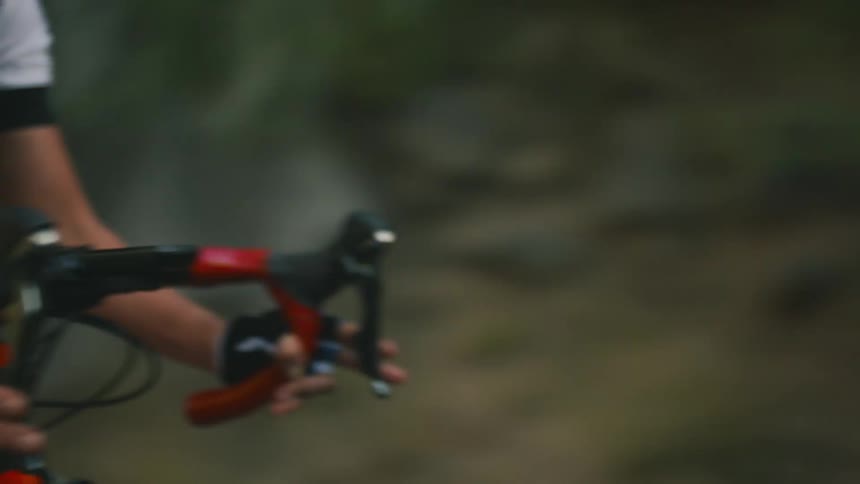 A woman is racing her mountain bike on the road