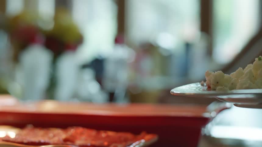 Person serves themselves bacon onto their plate using metal tongs