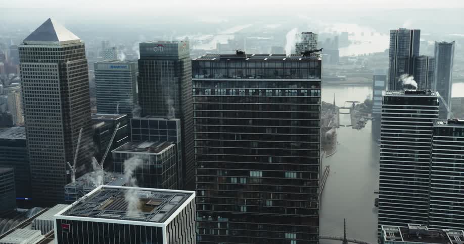 An aerial view of high rise office buildings on a river in a city