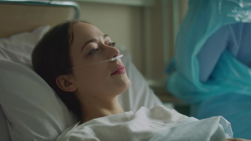 A view of a woman laying in a hospital with a doctor next to her
