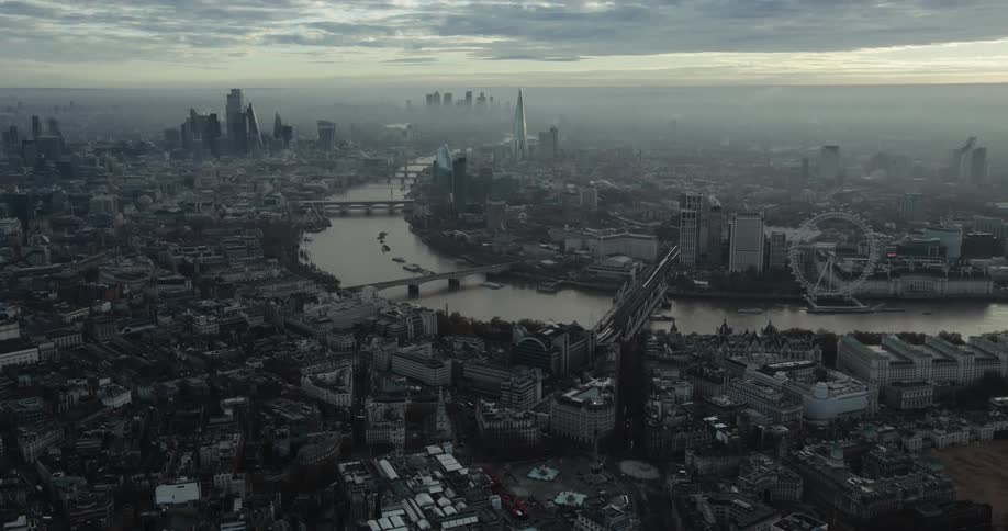 Aerial view of the thames river through the city of london covered in smog in the morning