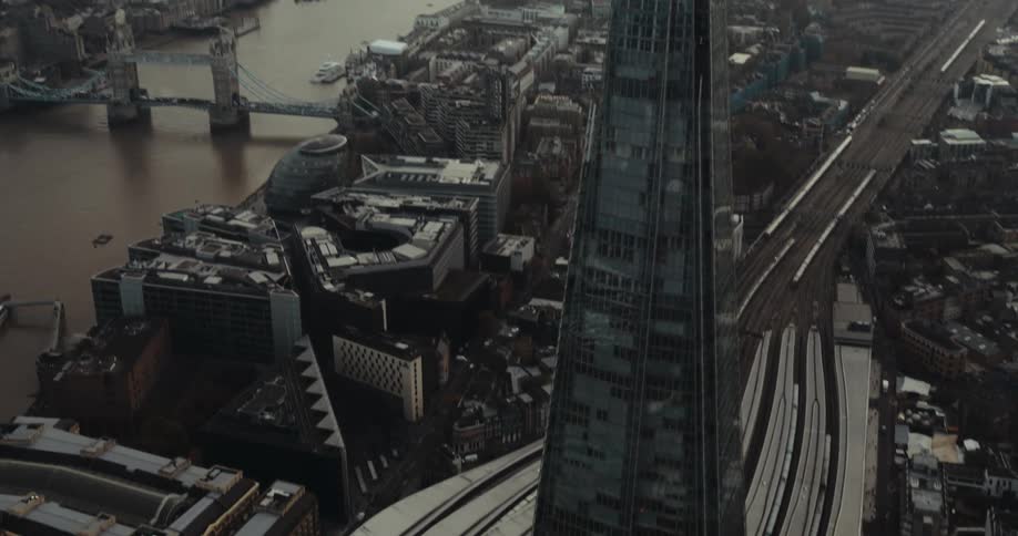 An aerial view of a tall skyscraper in a city on a cloudy day
