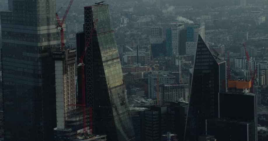 Construction cranes sit alongside tall skyscrapers