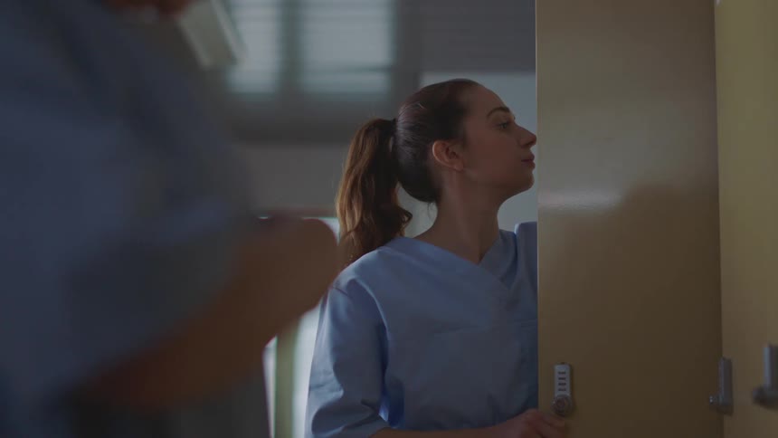 A nurse arranges the contents of her locker in a hospital during the day
