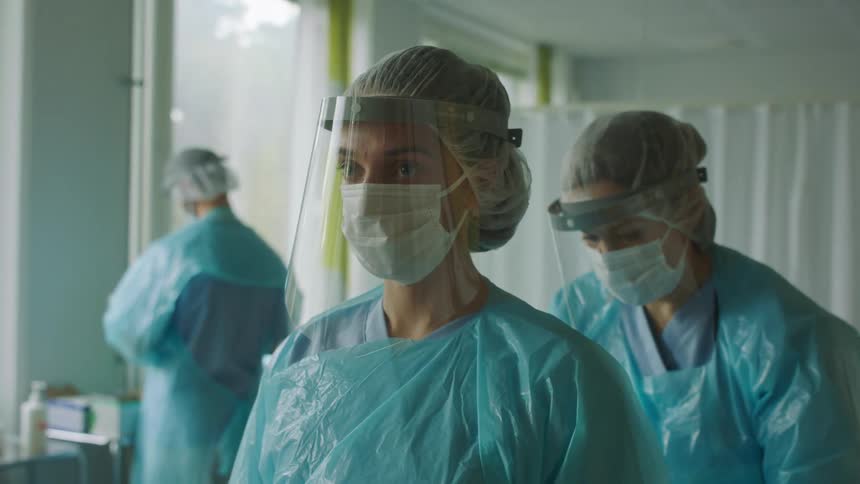 A group of doctors putting on clothes