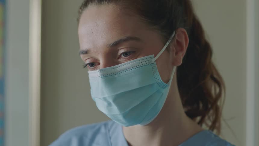 A woman doctor in a room wearing a mask