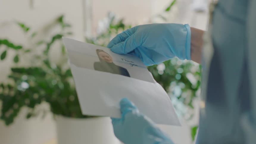 A doctor opening an envelope with a picture in it