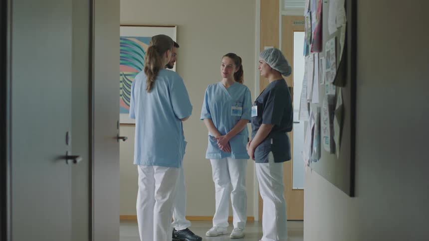 Nurses and doctors chat in a hospital hallway