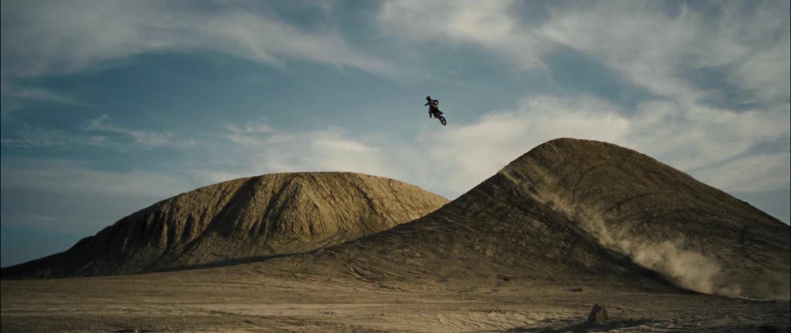 A person jumping a dirt bike off a jump