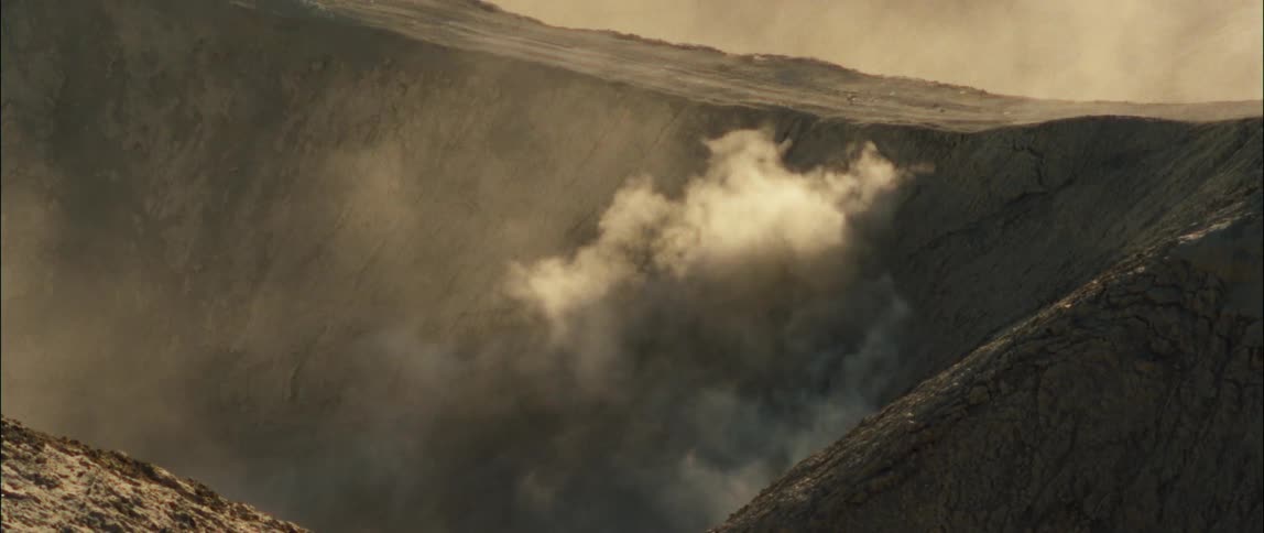 A dirt biker rides up and down the sides of a canyon