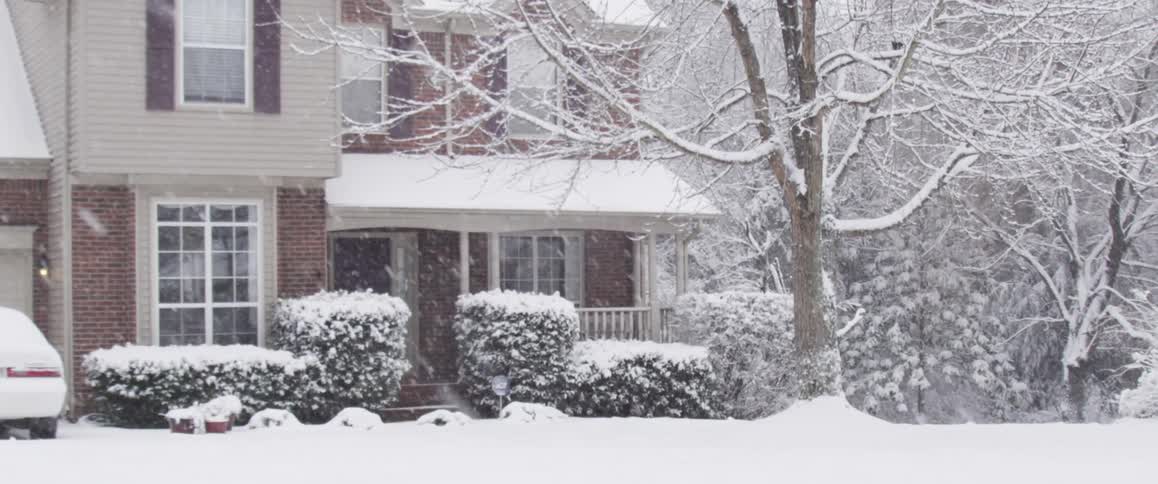 View of a home as snow falls