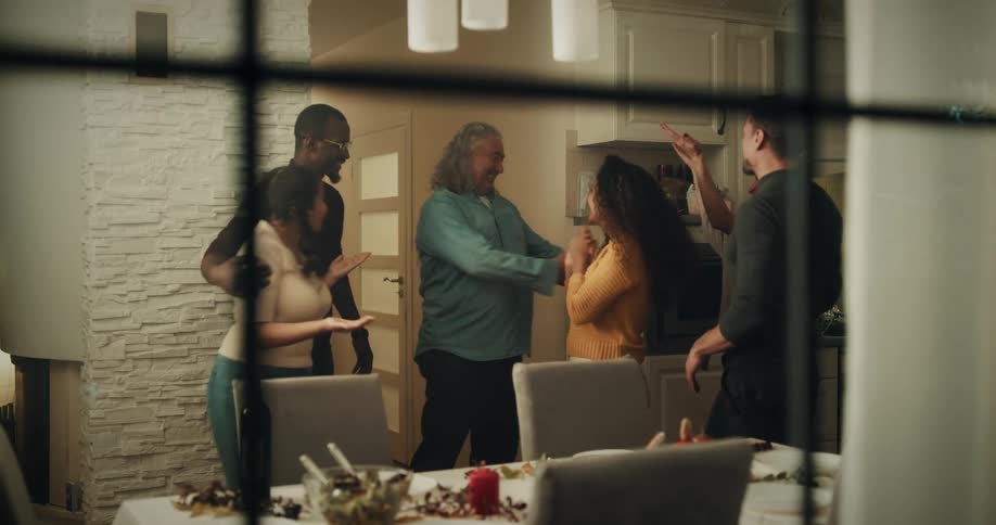 A group of friends hug as they meet up at a house for dinner