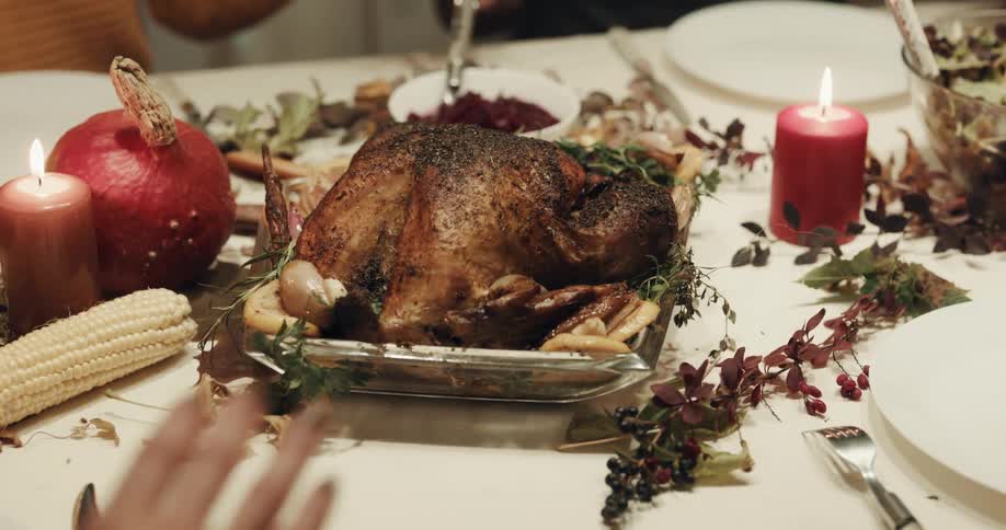 People sitting at table holding a holiday meal clasp hands
